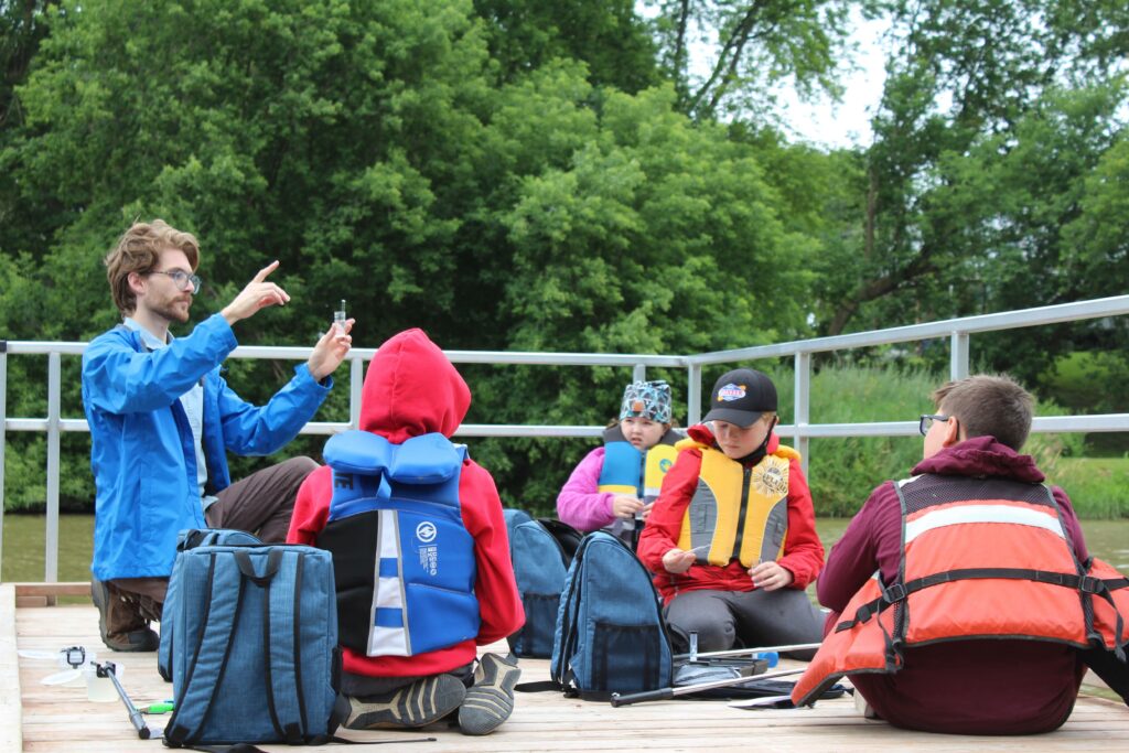 A group of young students on a dock water testing