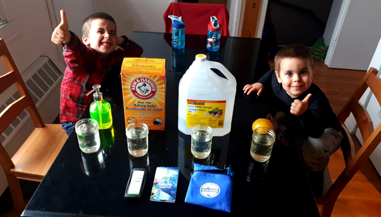 Kids testing dish soap, vinegar, and baking soda with Water Rangers tools. 